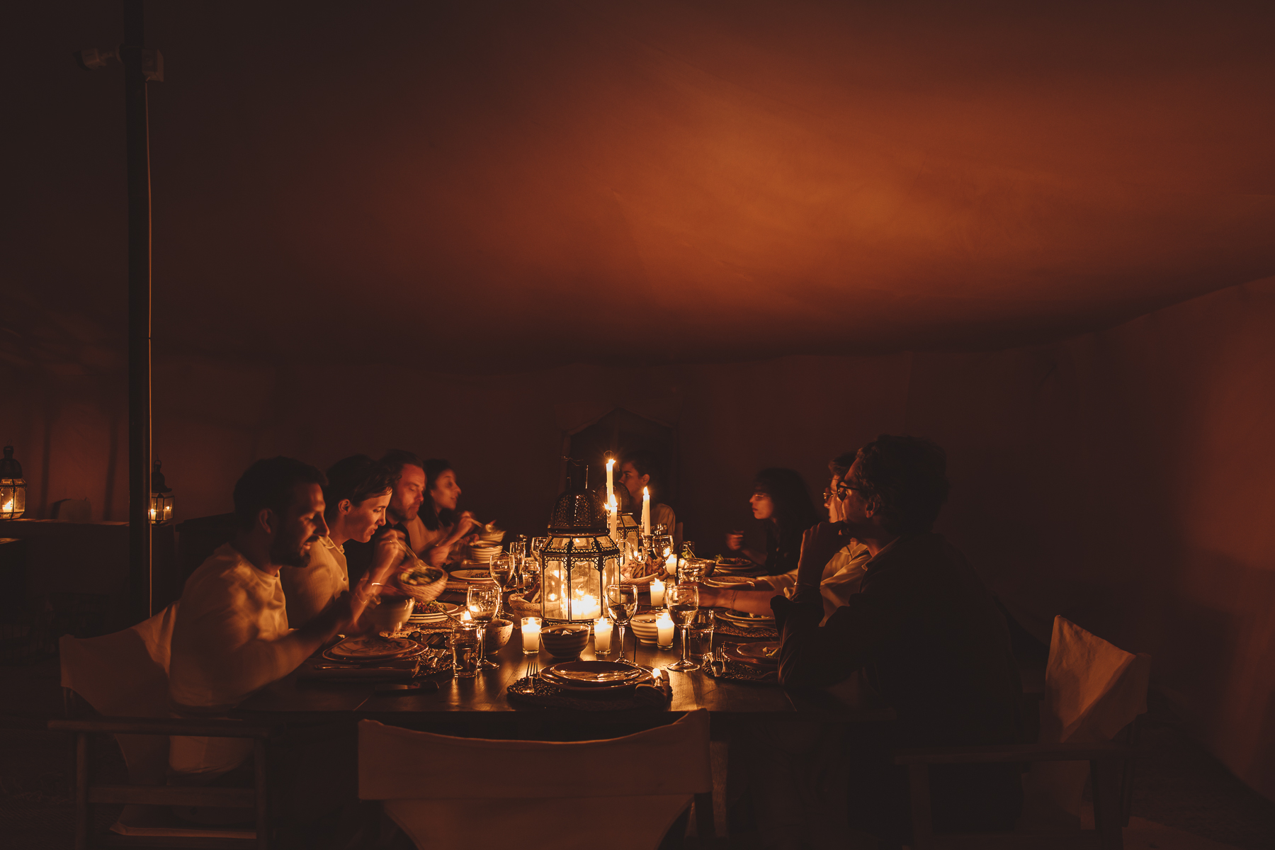 Cena privata aziendale a lume di candela in tenda berbera nel deserto