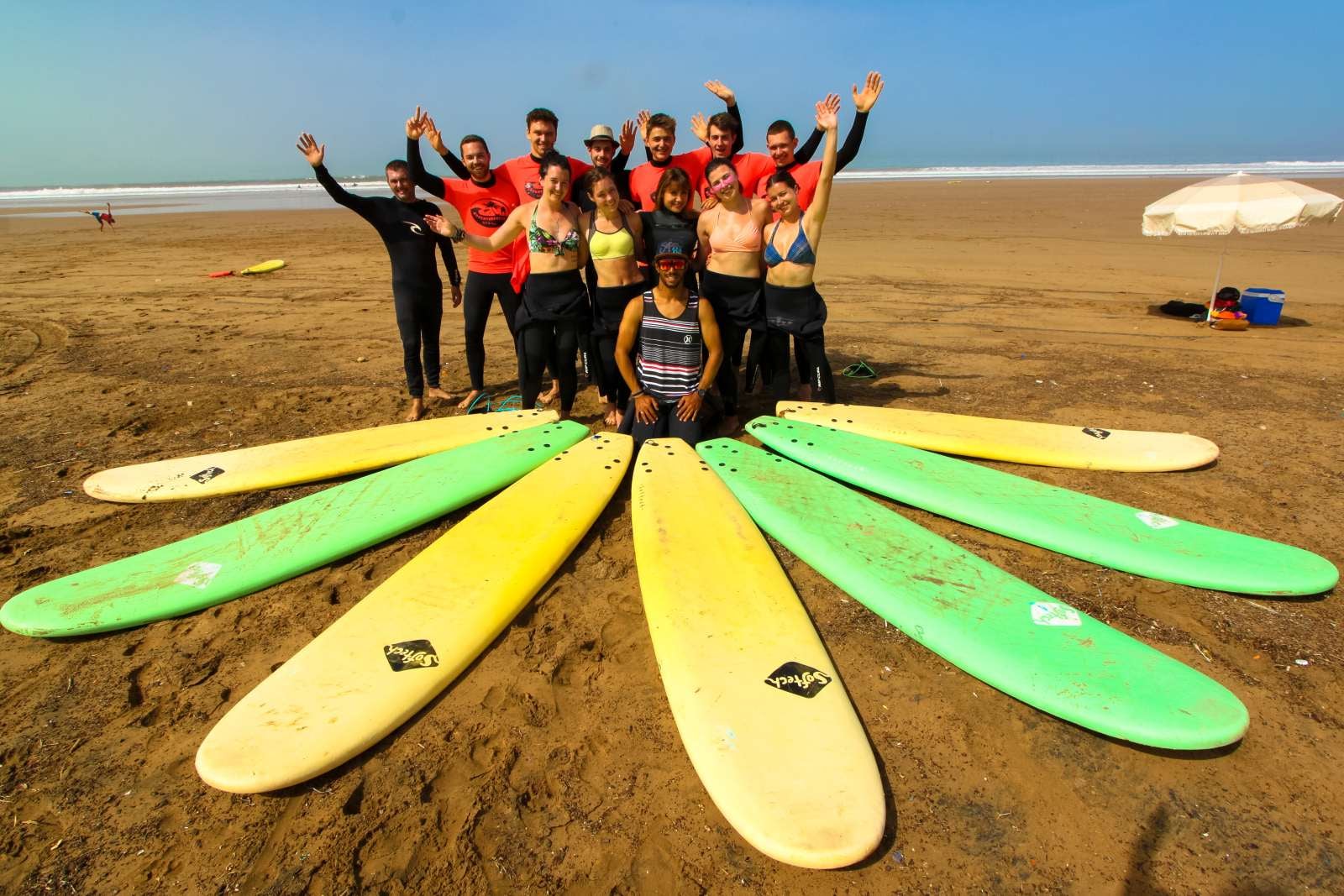 Gruppo aziendale a lezione di surf sulle onde dell'Atlantico in Marocco durante un retreat